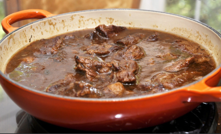 A picture of an orange ceramic skillet with flemish beef n beer stew